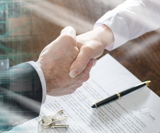 Estate agent shaking hands with his customer after contract signature; multiple exposure
